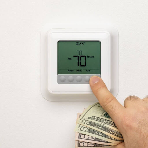 A person with money left in hand after saving on Topeka thermostat service